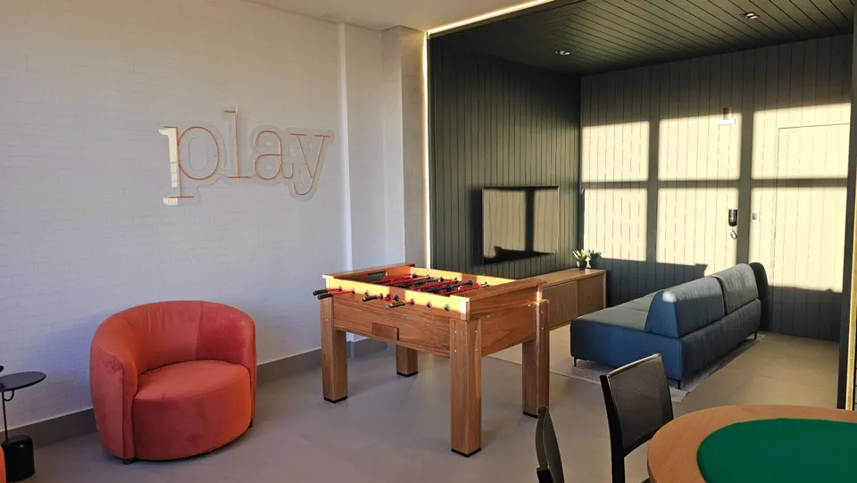 Salão de jogos com pebolim e sofás