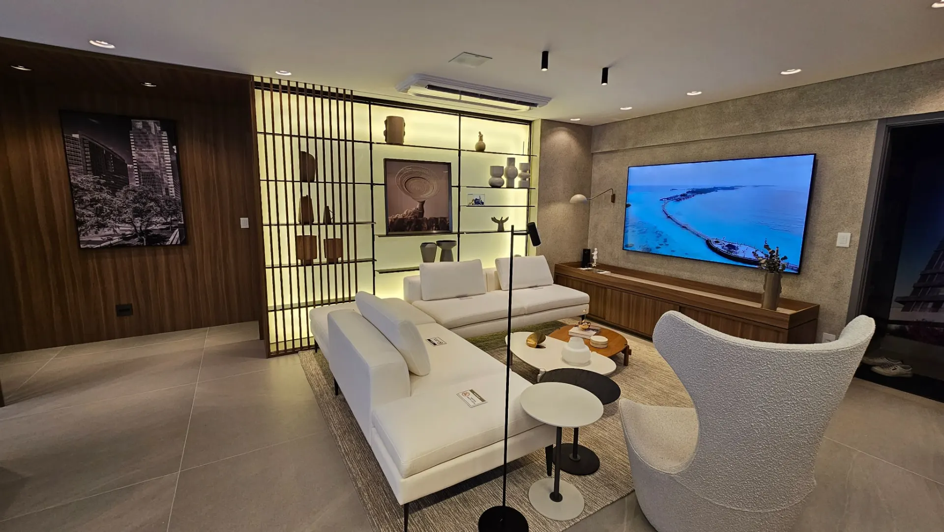 Living amplo com painel em madeira no apartamento decorado de 120 m² do Signature Royal Park